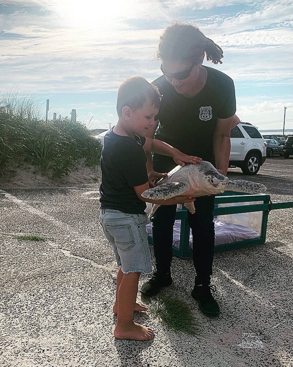 Animal Control Officer and Little Boy Hold a Turtle